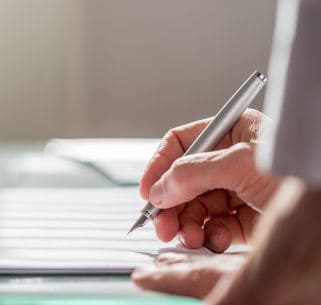business person writing on a document